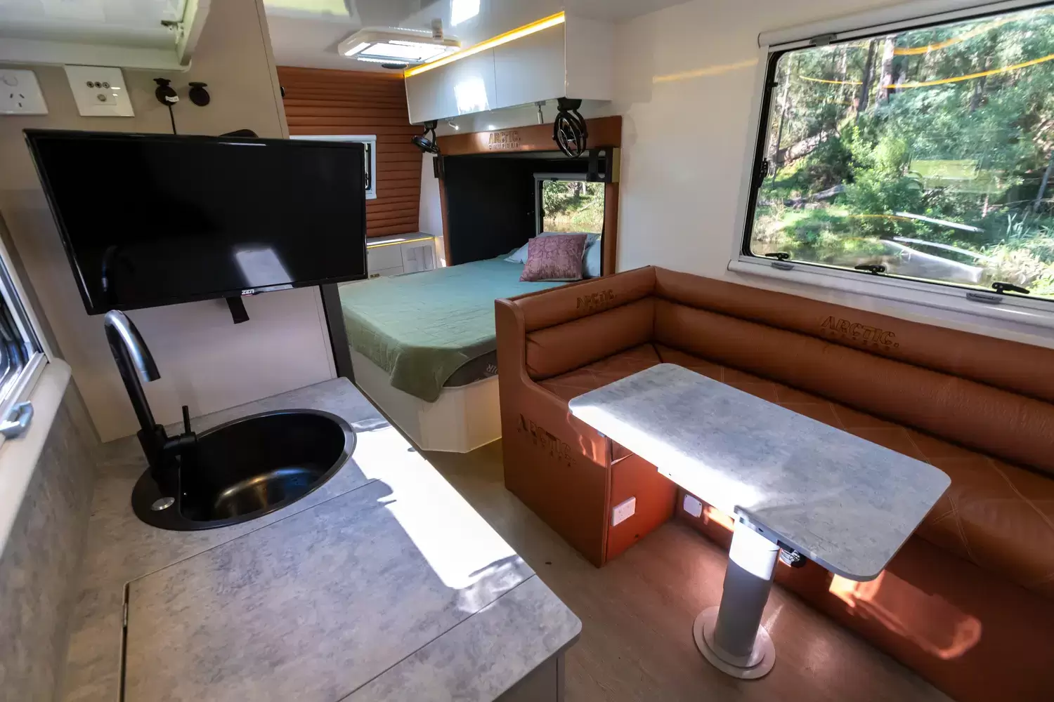 Polar 18 interior showing the kitchen, lounge, dining table and bed